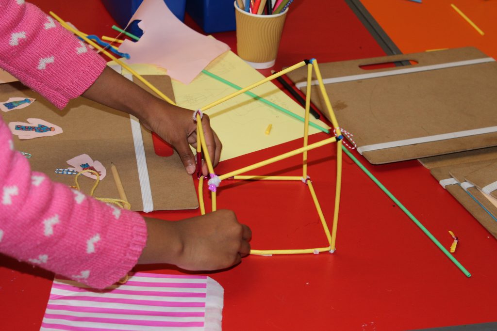 A child's hands working on a craft project.